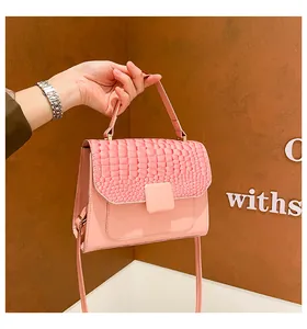 Detail of pink crocodile embossed leather texture and decorative square buckle on handbag