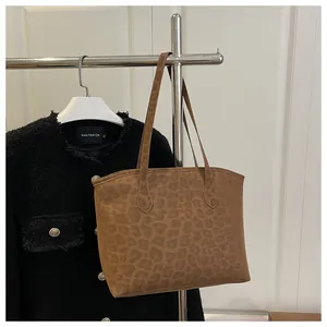 Close-up of leopard print tote bag with soft suede texture hanging on a metal rack