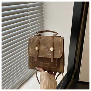 Close-up of vintage brown leather bag featuring cat illustration and stylish top handle