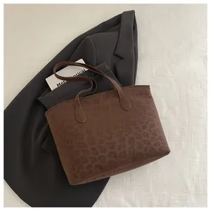 Detailed view of leopard print tote bag with long handles and soft velvet texture