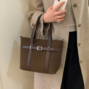 Detail view of vintage dark brown tote bag with leather strap and silver buckle detail