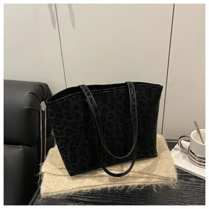 Close-up of leopard print tote bag on a fringe blanket with a coffee cup prop