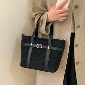 Retro black bucket tote bag with leather strap accents and silver buckles for winter