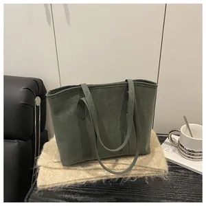 Detailed view of dark green suede leopard embossed tote bag with slim shoulder straps