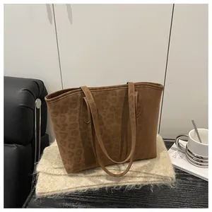 Detailed view of leopard print suede tote bag styled with a scarf and coffee cup