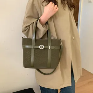 Olive green bucket bag featuring premium fabric texture and leather strap buckle detail