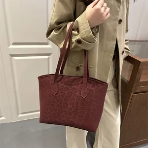Leopard print burgundy tote bag worn by model with neutral autumn trench coat outfit