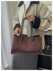 Deep brown suede tote bag styled with a green trench coat for a minimalist look