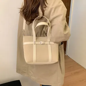 Detailed side view of a beige vintage bucket bag with elegant buckle leather strap accent