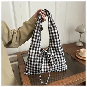 Close-up of black and white gingham fabric tote bag with elegant ribbon bow detail