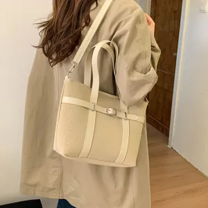 Detail showing the woven texture of the beige bucket bag with decorative leather strap