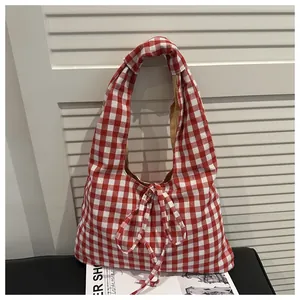 Close-up of red and white gingham tote bag with a decorative bow and canvas texture