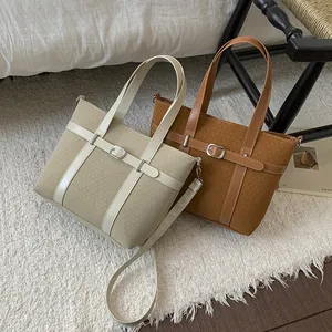 Detailed view of beige and brown textured bucket bags with leather straps and metal buckles