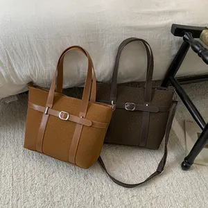 Close-up of retro bucket bags showing grainy fabric texture and leather strap details