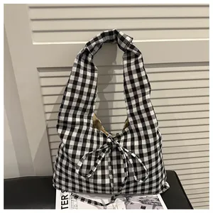 Close-up of black and white gingham fabric tote bag with a decorative ribbon bow