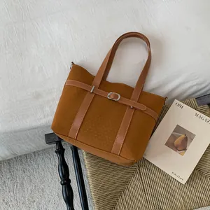 Detailed view of vintage brown bucket bag with buckle strap and textured fabric