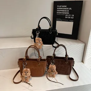 Drei Leopardenmuster Eimertaschen in Schwarz und Braun mit Bärenanhänger und Gurt