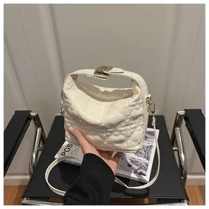 Détail du sac à main blanc crème avec surpiqûres en cœur et fermoir en métal doré