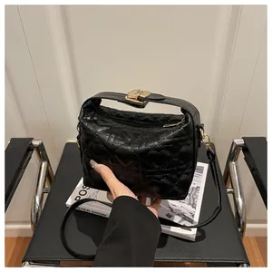Détails d'un sac à main noir matelassé avec motifs de cœur et finitions dorées