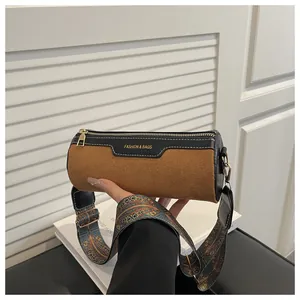 Detail of cylinder shoulder bag with ethnic wide strap and contrast leather stitching