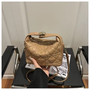 Détail d'un sac matelassé marron clair avec coutures en cœur sur une chaise