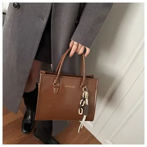 Chic brown leather tote bag with chain scarf charm and Fashion & Bags embossed logo