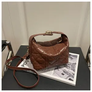 Détail du sac à main en cuir marron avec matelassage cœur et fermoir doré chic