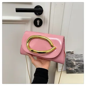 Detailed shot of pink patent leather handbag with gold ring buckle and chain strap