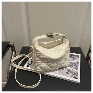Détail du sac bandoulière blanc avec surpiqûres en cœur et boucle en métal doré