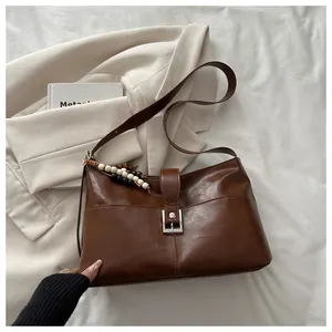 Detail view of deep brown vintage shoulder bag with silver buckle and beaded charms