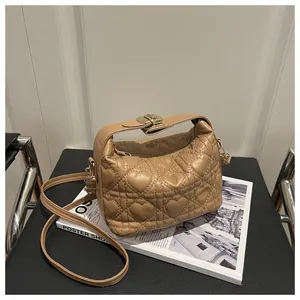 Détail du matelassage en forme de cœur et du fermoir en métal argenté du sac beige