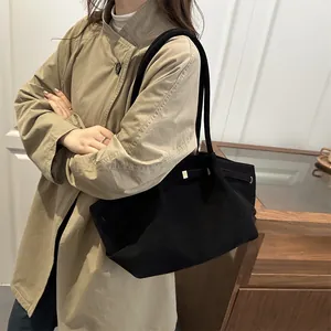 Vintage black suede bucket bag with gold buckle and adjustable strap shown on a model