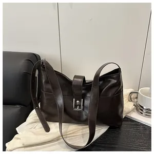 Detail of vintage dark brown faux leather shoulder bag with vertical stitching and metal buckle