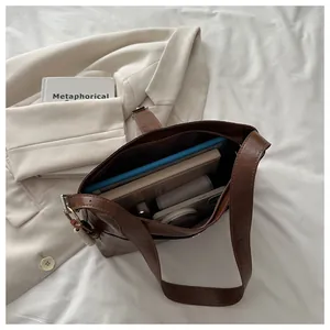 Top view of brown leather bag showing spacious interior with tablet and notepad