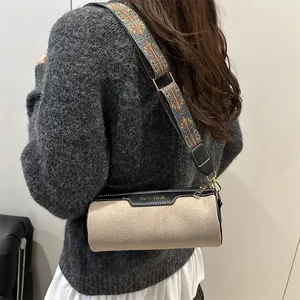 Beige cylindrical crossbody bag with vintage jacquard strap and black leather trim
