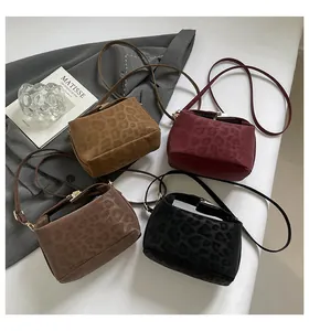 Detailed close-up of leopard print crossbody bags in yellow, burgundy, coffee, and black