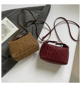 Detail of leopard print faux suede small square bags in camel and burgundy tones