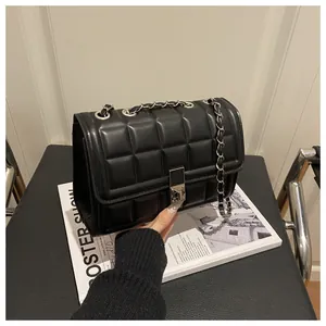 Top view of black quilted faux leather crossbody bag with silver clasp and chain strap