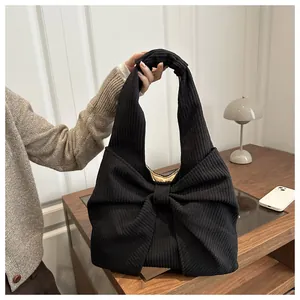 Détail du sac en velours côtelé noir avec grand nœud et doublure jaune vif