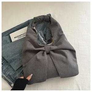 Gros plan du sac cabas en velours côtelé gris foncé avec un grand nœud décoratif