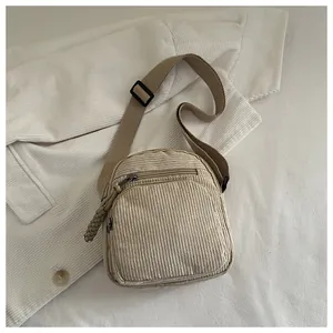 Détail de la texture velours côtelé et de la poche zippée du sac kaki