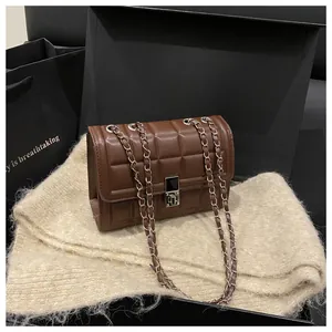 Detail of dark brown checkered crossbody bag with chain strap and metallic lock clasp
