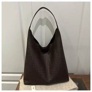 Gros plan sur la texture en cuir tressé marron foncé et le design souple du sac Hobo