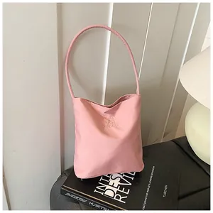 Primer plano del bolso saco rosa pálido con bordado y textura de lona de alta calidad