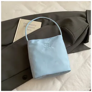 Detalle del bolso tote de nailon azul claro con bordado Hope and future en tela texturizada