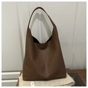 Vue détaillée de la texture tressée marron et de la structure souple du grand sac