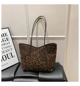 Detailansicht der Leopard-Print Shopper-Tasche mit braunem Lederbesatz auf einer Bank