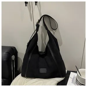 Macro view of matte black tote bag with smooth piping and adjustable shoulder strap