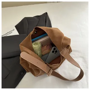 Interior view of brown suede handbag showing large capacity with umbrella and phone