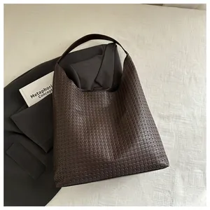 Détail de la texture en cuir tissé sur un sac hobo marron foncé pour femme chic